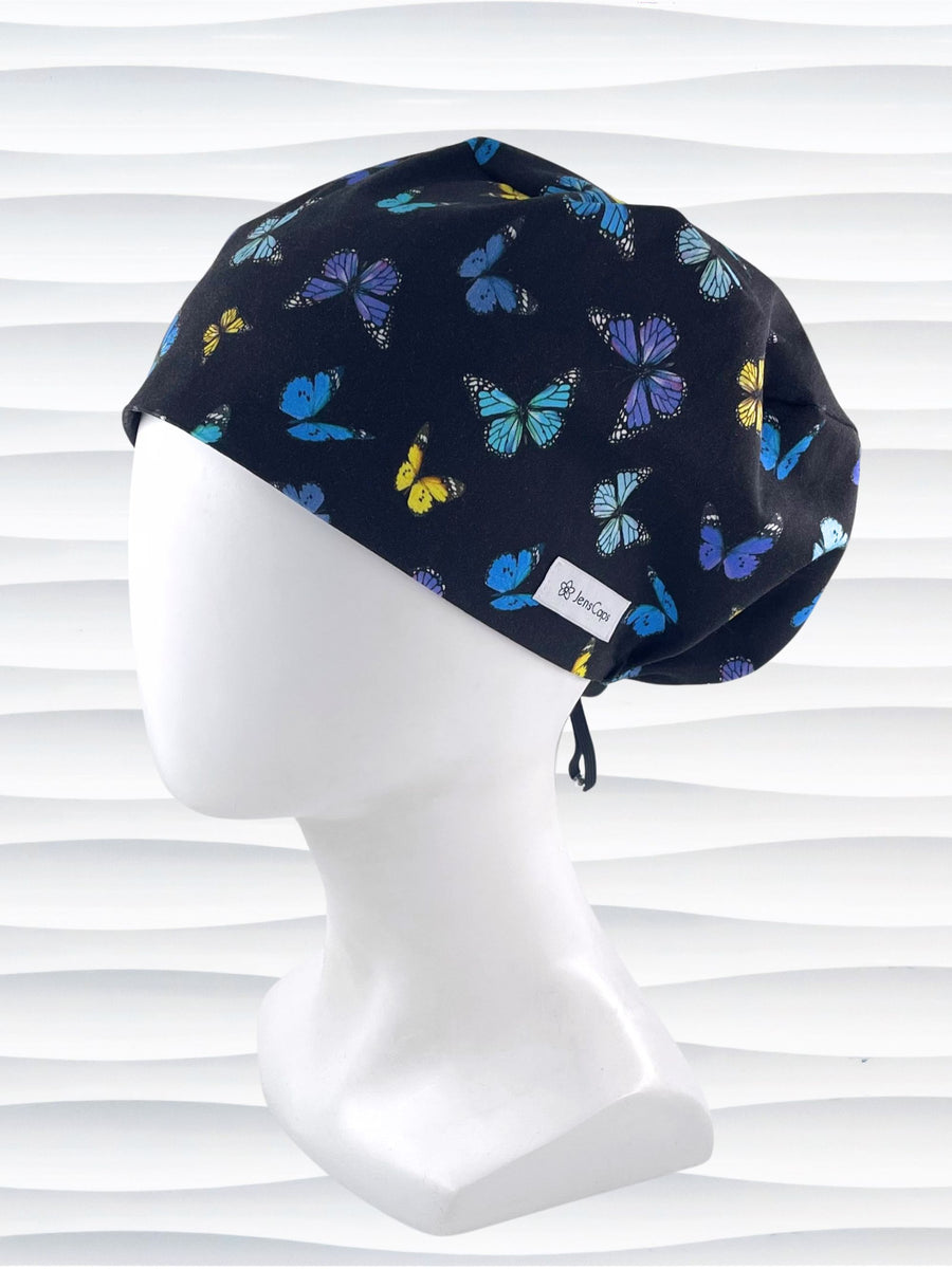 Euro Pixie style surgical scrub cap hat with blue, purple, and yellow butterflies all over black cotton fabric.