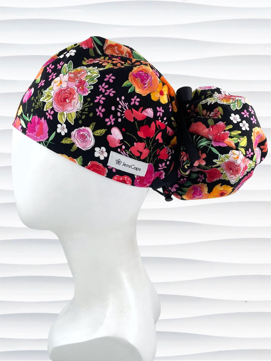 Pony Hybrid style surgical scrub cap hat with red and pink and orange flowers on black cotton fabric.