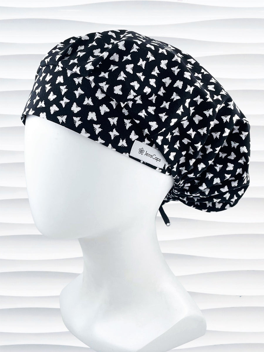 Original Bouffant style scrub cap hat with white butterflies on black cotton fabric.