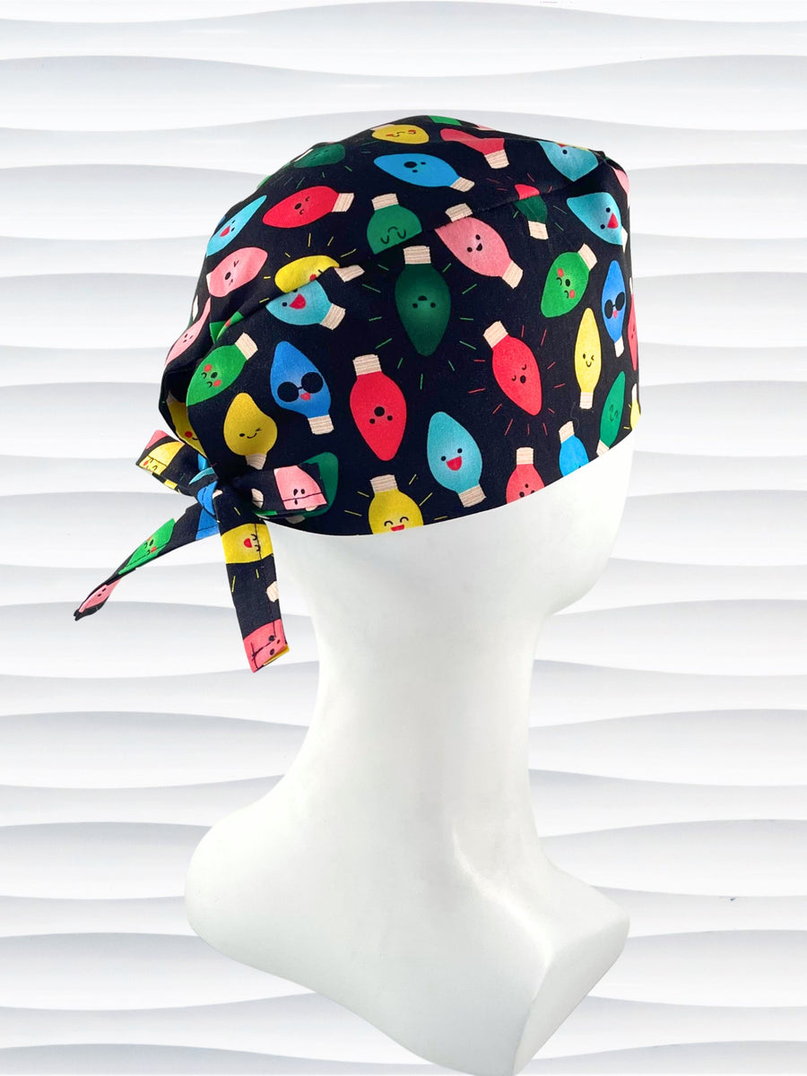 Surgeon style surgical scrub cap hat with smiling animated christmas lights in red green yellow and blue on black cotton fabric.