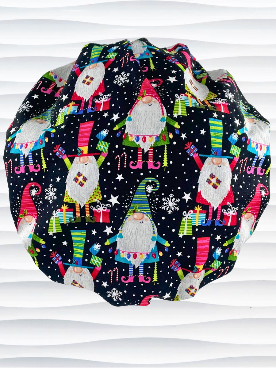 Bouffant style surgical scrub cap hat with holiday gnomes, christmas trees, and gifts in bright colors on black cotton fabric.