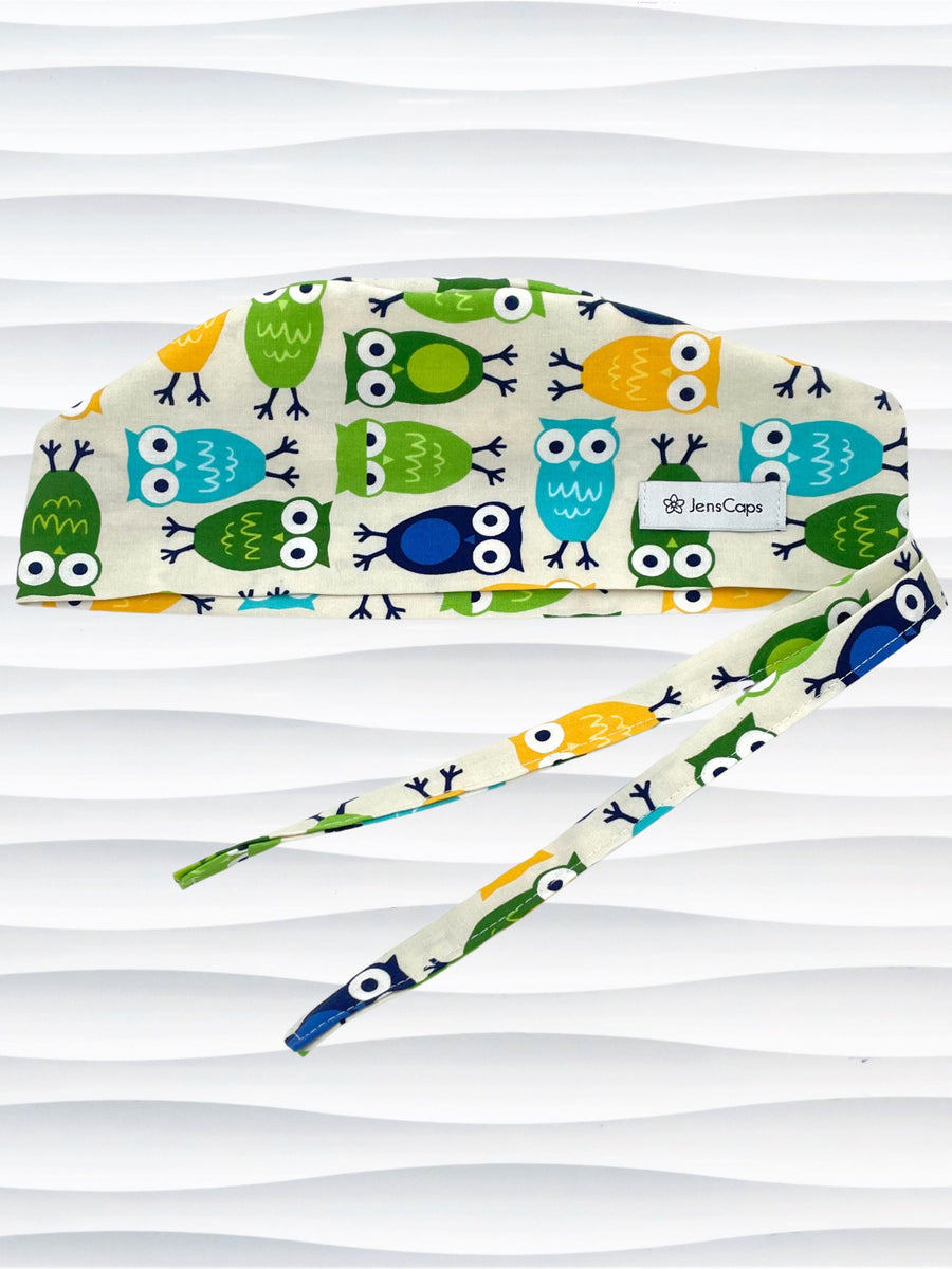 Surgeon style surgical scrub cap hat with an allover print of cute owls in blue green, and yellow on cotton fabric.