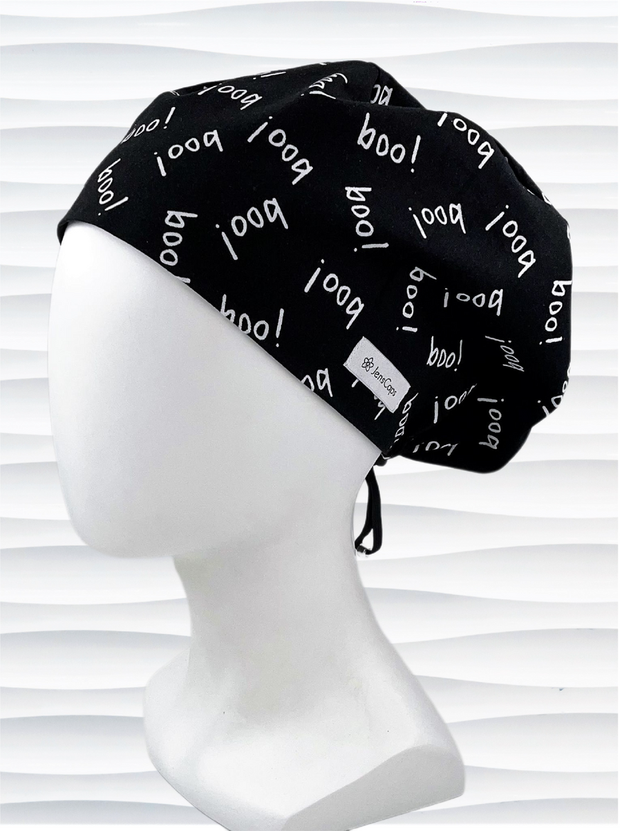 Pixie Euro style surgical scrub cap hat with the word boo in white print tossed all over this black fabric.