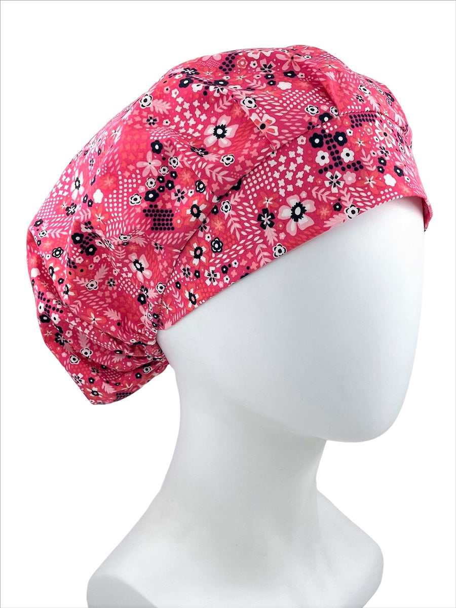 Bouffant surgical scrub cap hat with black and pink and white flowers on pink premium cotton fabric.