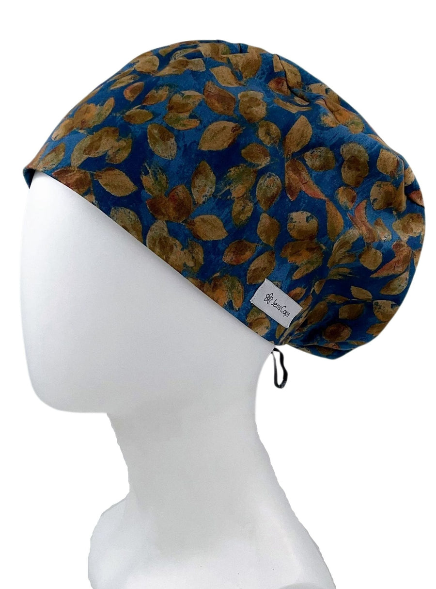 Surgical Scrub Cap Hat for men or women.  This cotton fabric has an allover print of tossed aspen leaves in various shades of brown and gold on a midnight blue background.  