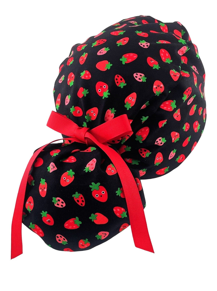 Ponytail style scrub cap hat with red strawberries on black premium cotton.