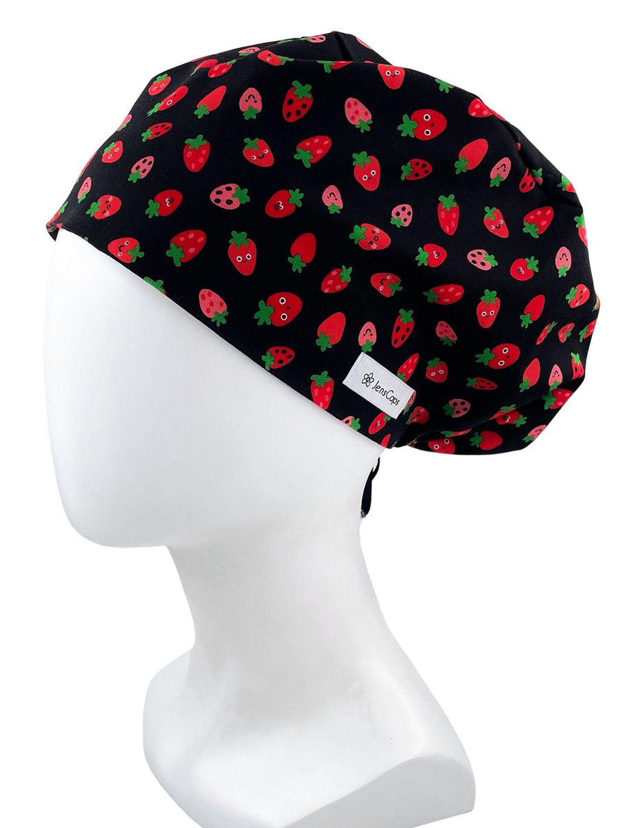 Pixie Euro style scrub cap with red strawberries with smiling faces on a black premium cotton fabric.