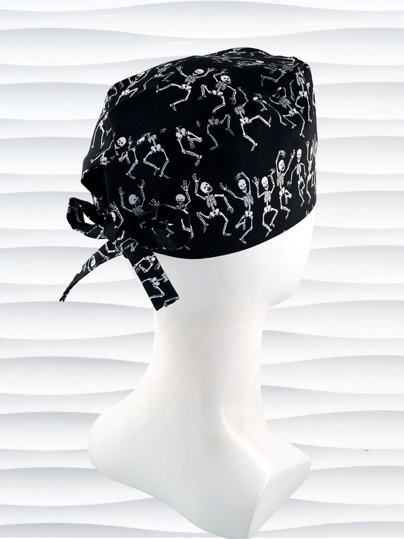 Surgeon style surgical scrub cap hat with dancing skeletons in white and gray on black cotton fabric.
