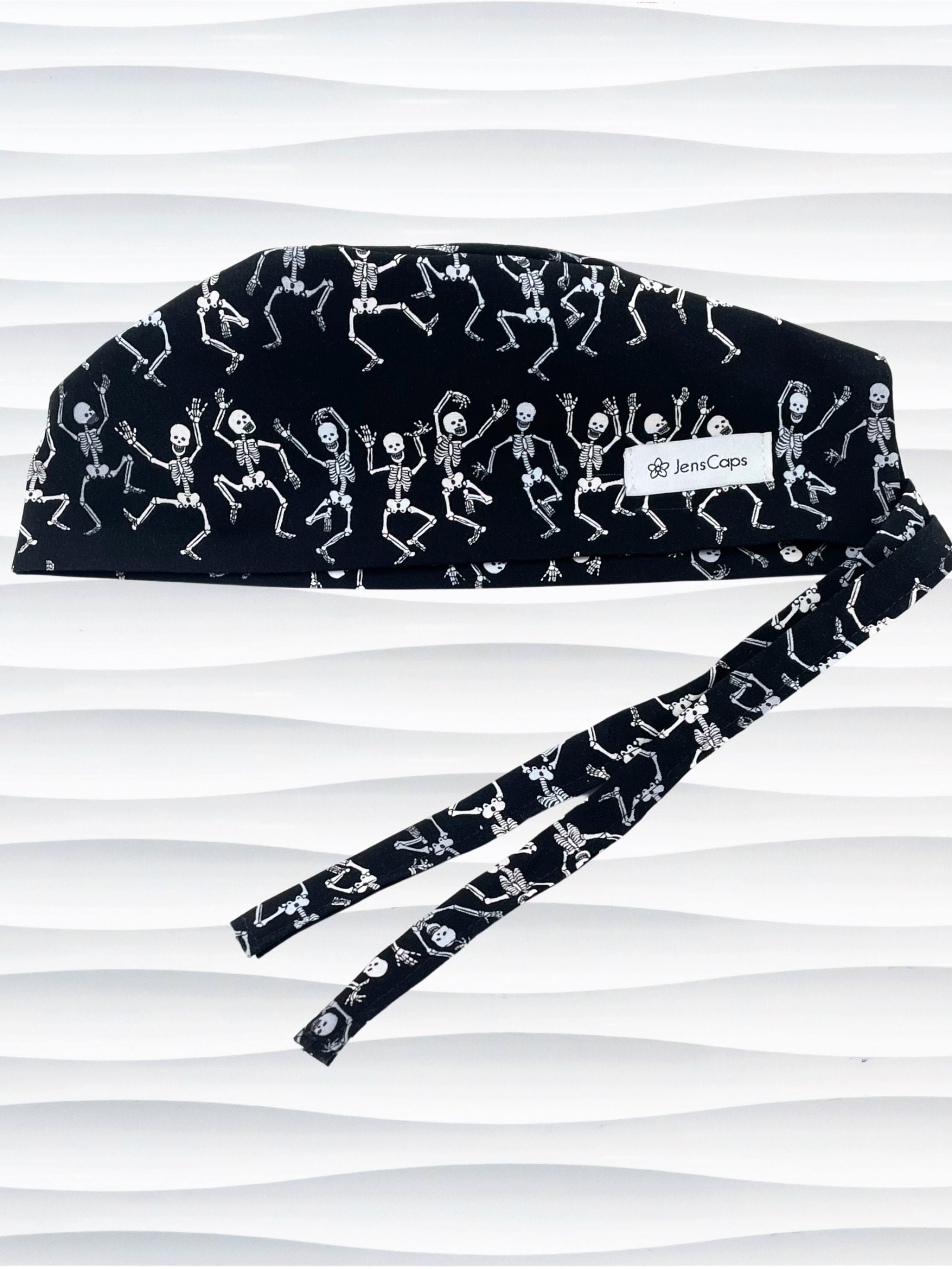Surgeon style surgical scrub cap hat with dancing skeletons in white and gray on black cotton fabric.