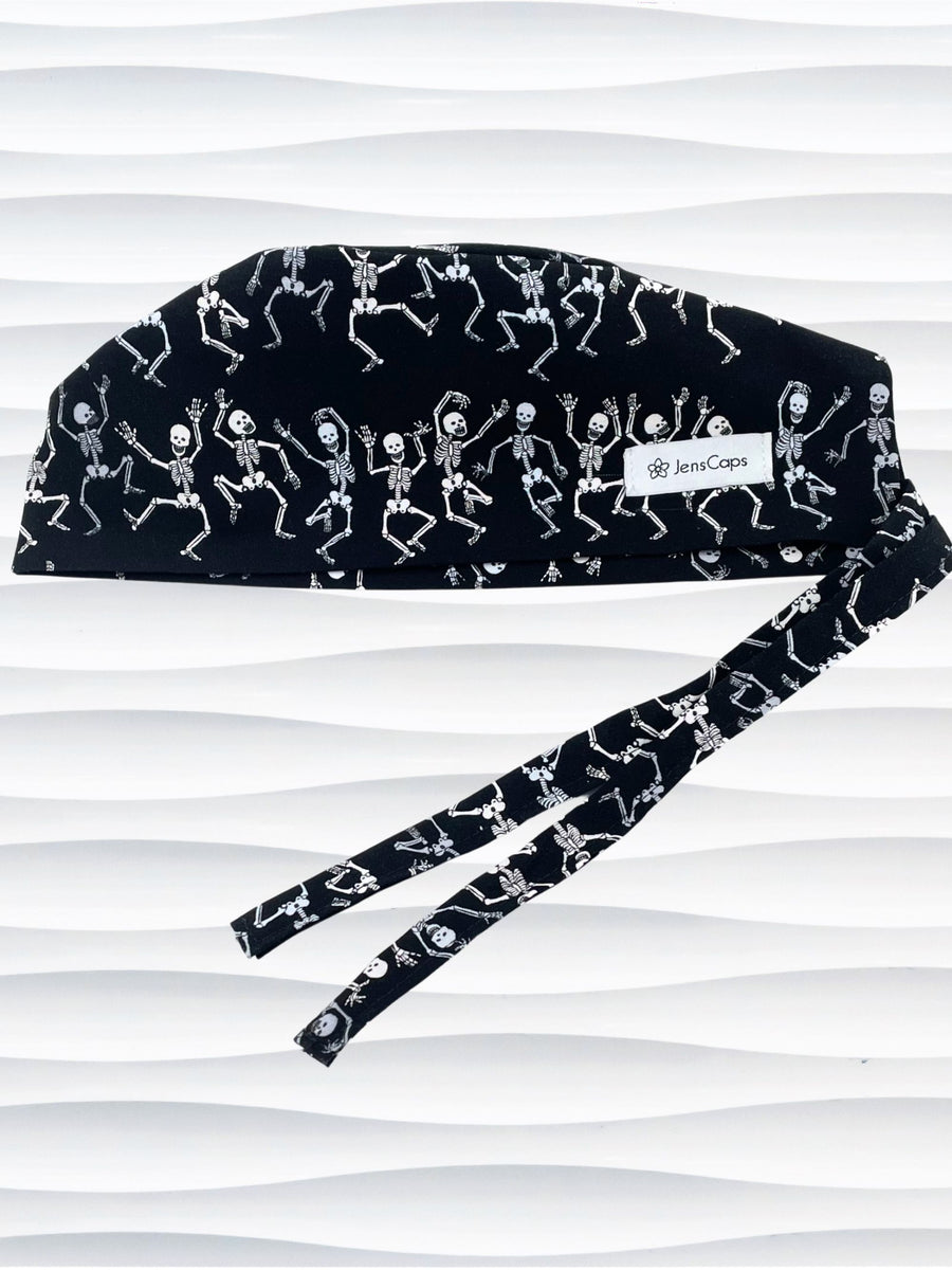 Surgeon style surgical scrub cap hat with dancing skeletons in white and gray on black cotton fabric.