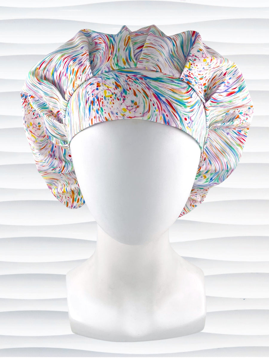 Bouffant style surgical scrub cap hat with pastel oil slick swirls all over this white cotton fabric.