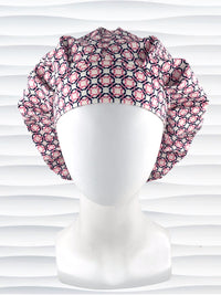 Bouffant style surgical scrub cap hat with pink and blue circles and squares in a trellis pattern on cotton fabric.