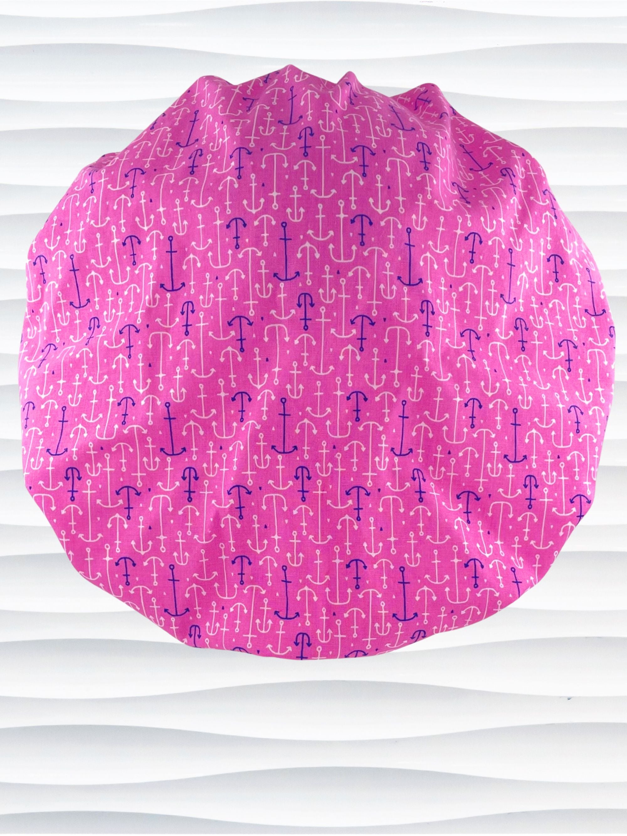 Bouffant style surgical scrub cap hat with purple and white anchors all over this pink cotton fabric