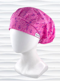 Bouffant style surgical scrub cap hat with purple and white anchors all over this pink cotton fabric