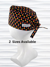 A black tie back swtyle surgical scrub cap by JensCaps with a colorful candy corn pattern, displayed on a white mannequin head. 