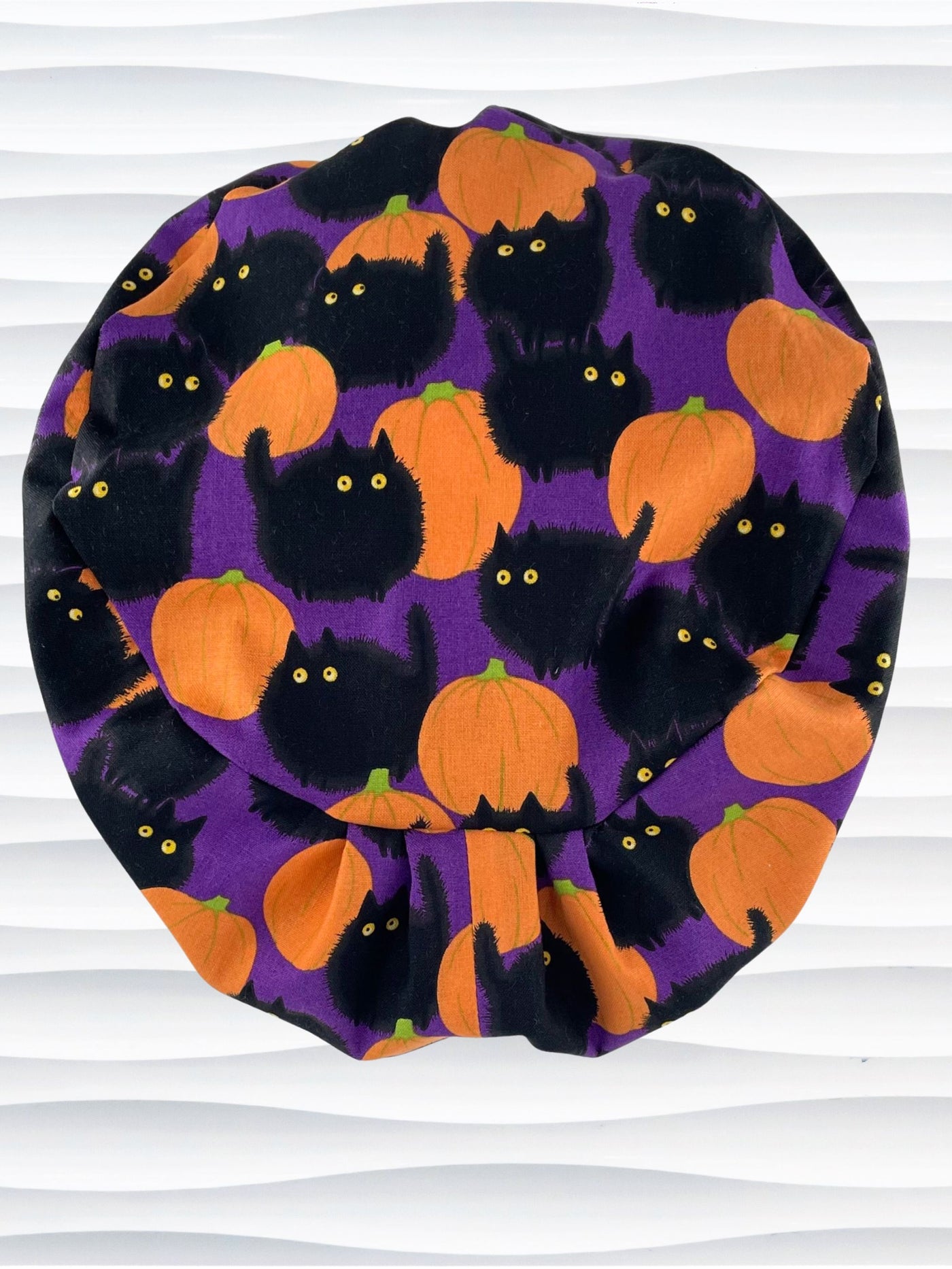 Euro Pixie style surgical scrub cap by JensCaps with black puffy cats in a pumpkin patch on purple background cotton fabric.