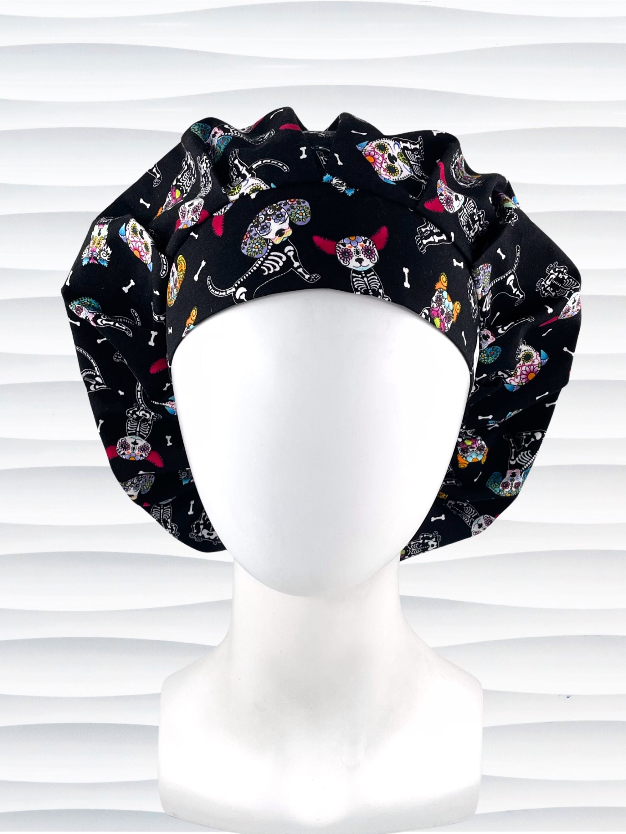 Bouffant style surgical scrub cap hat with sugar skull dogs in bright colors on black cotton fabric.