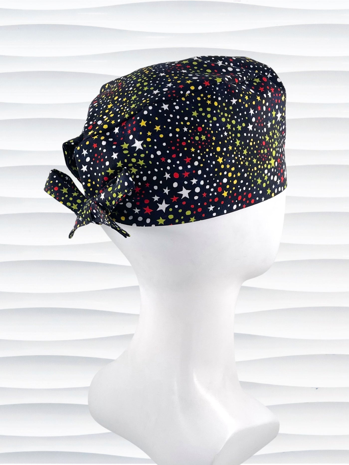 Mens surgeon style scrub cap hat with red, green, and yellow stars and white dots all over black cotton fabric.