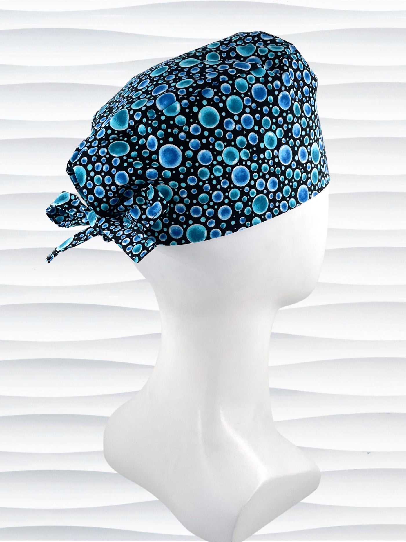 Mens surgeon style surgical scrub cap hat with blue bubbles all over black cotton fabric.