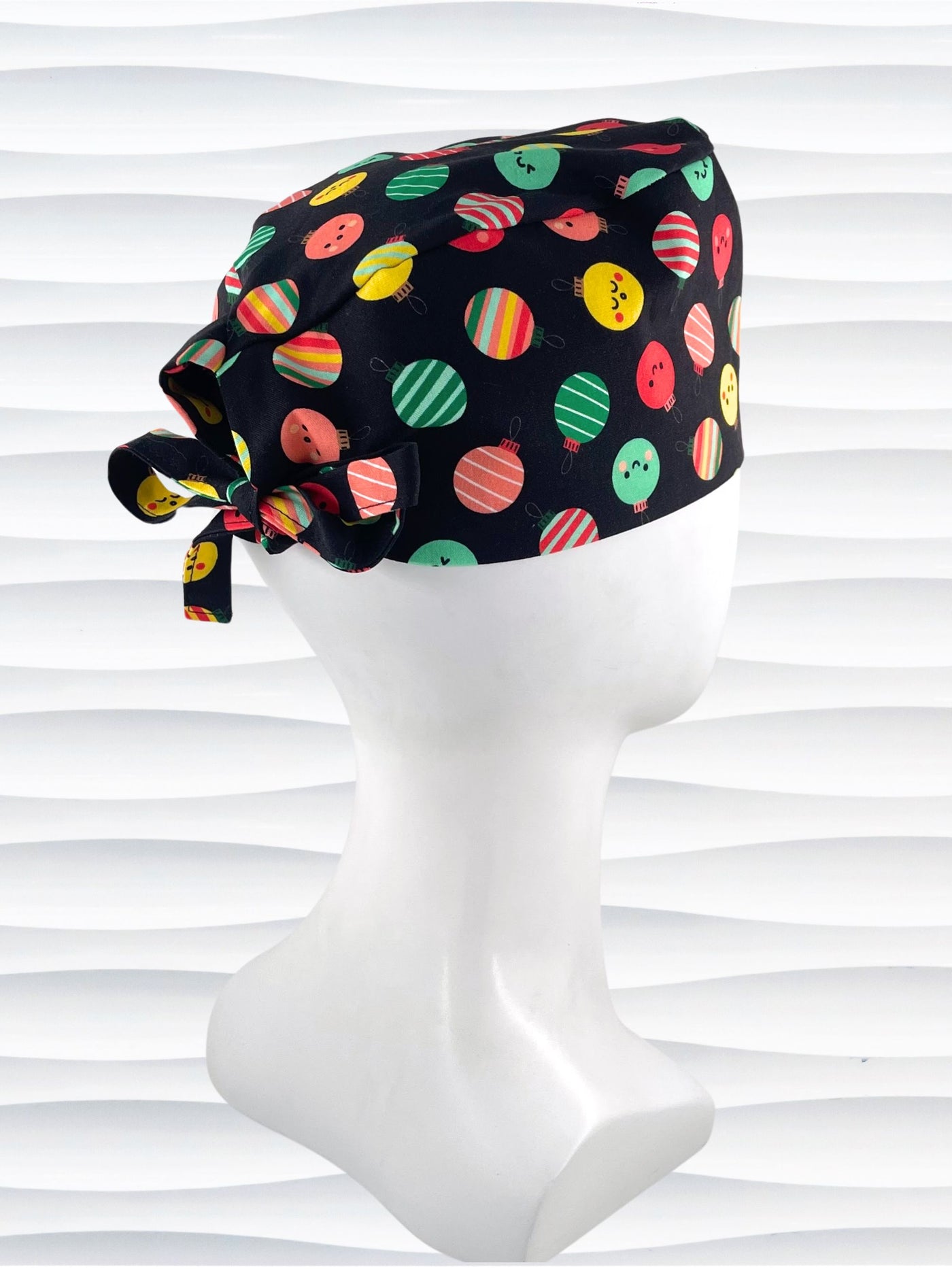 Mens surgeon style surgical scrub cap hat with christmas ornaments with smiling faces or stripes in red, green, and yellow on black cotton fabric.