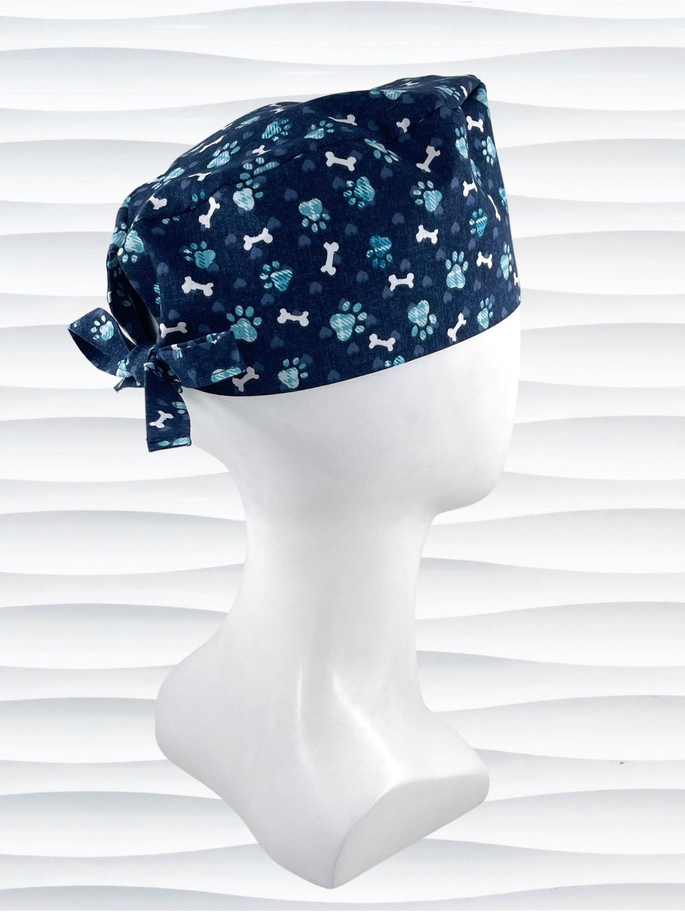 Mens Surgeon style scrub cap hat with white dog bones, blue dog paws, and blue hearts on dark blue cotton fabric.