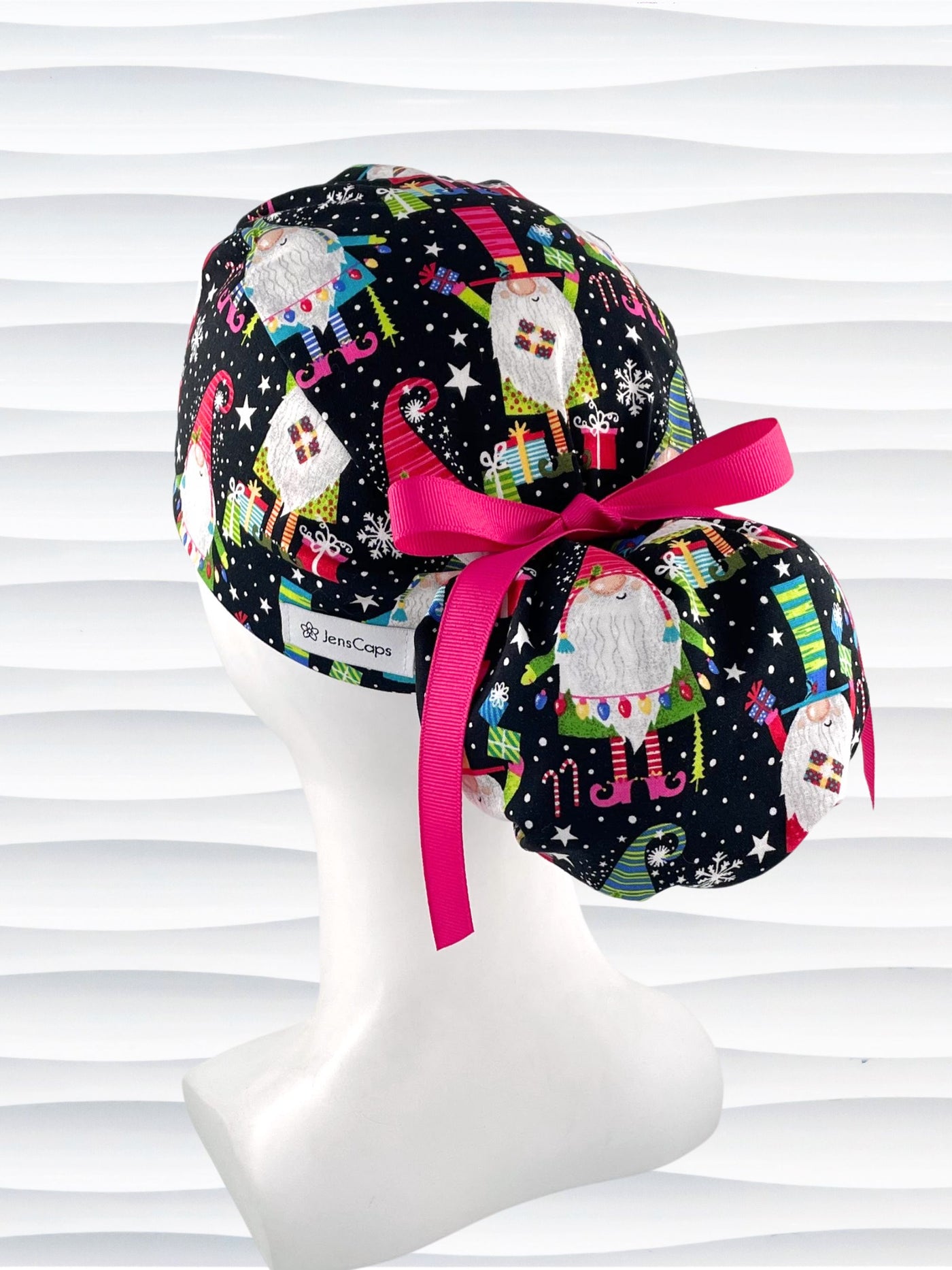 Ponytail style surgical scrub cap hat with christmas gnomes, stars, confetti, and gifts in bright colors on black cotton fabric.