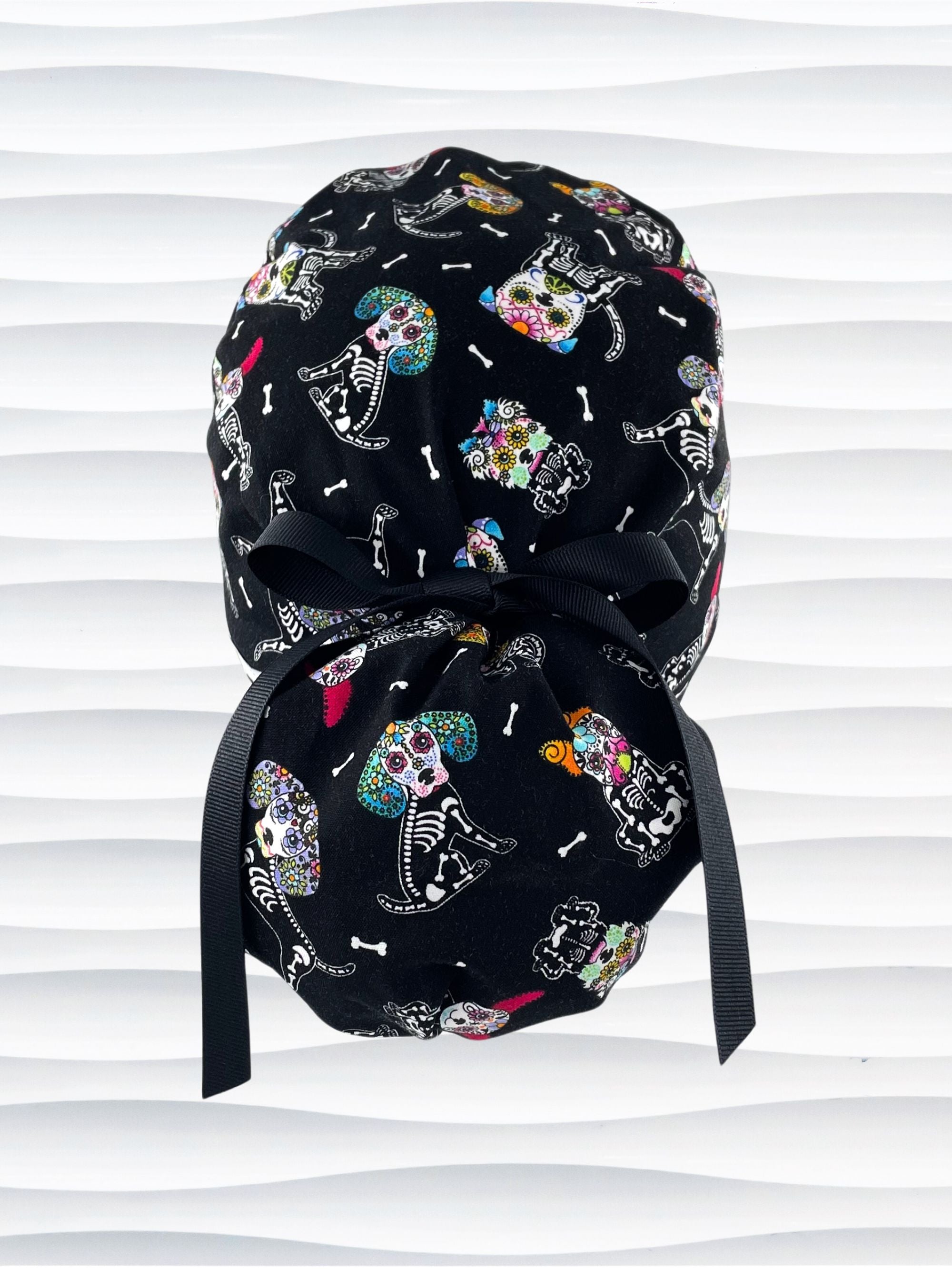 Euro Pony style surgical scrub cap hat for long hair with sugar skull dogs in bright colors on black cotton fabric.