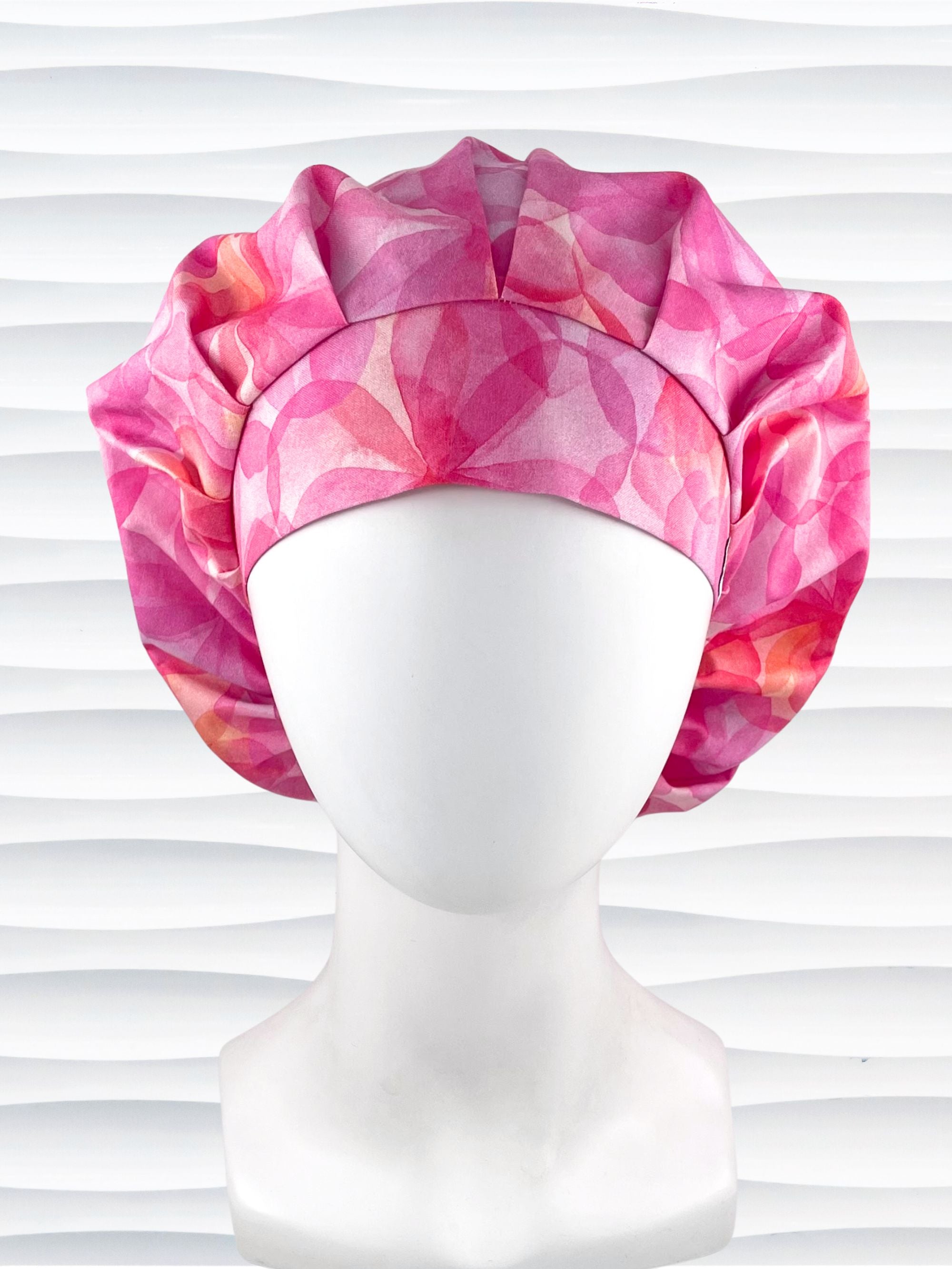 Bouffant style surgical scrub cap hat with large flowers in light and dark pinks and peach sorbet on cotton fabric.