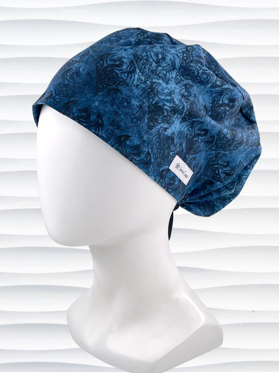 Euro Pixie style surgical scrub cap hat with subtle dragon shadows in blues and black on cotton fabric.