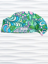 Euro Pixie style surgical scrub cap with a large and modern abstract floral print with swirls and butterflies in pinks, greens, and blues on cotton fabric.
