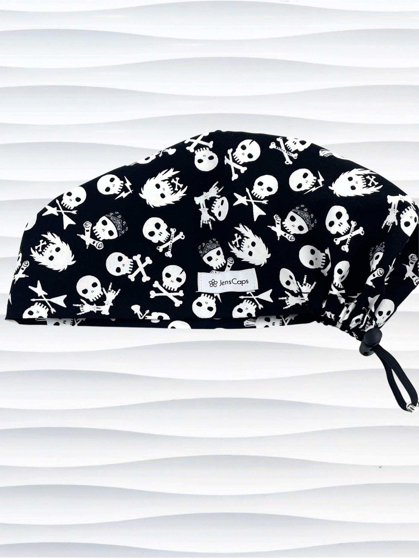 Euro Pixie style surgical scrub cap with white skulls, crossbones, and heavy metal hair all over this black cotton fabric.