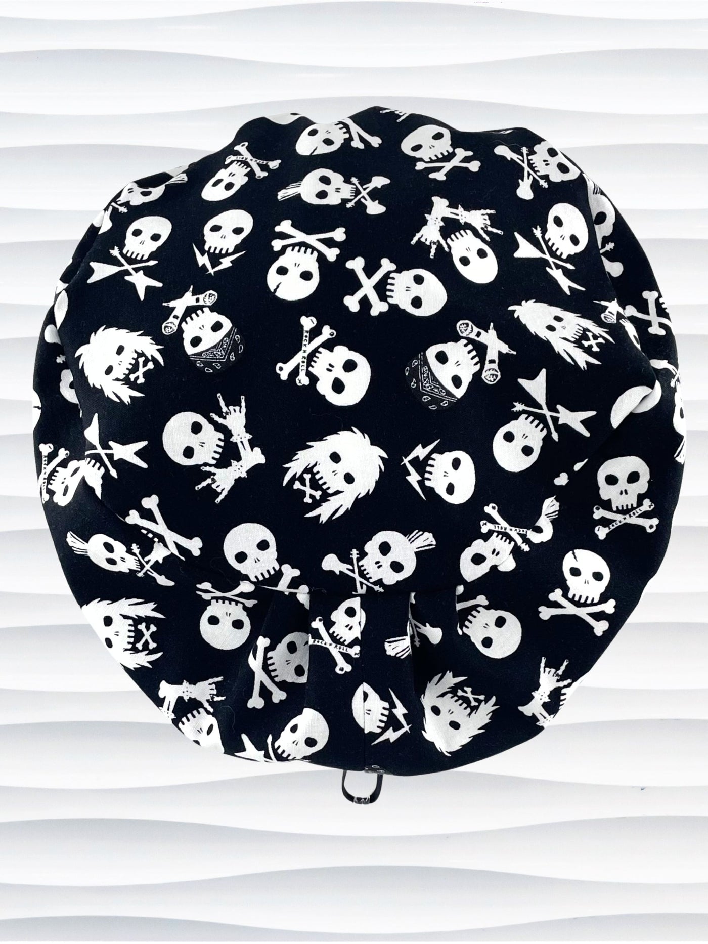 Euro Pixie style surgical scrub cap with white skulls, crossbones, and heavy metal hair all over this black cotton fabric.