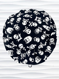Euro Pixie style surgical scrub cap with white skulls, crossbones, and heavy metal hair all over this black cotton fabric.