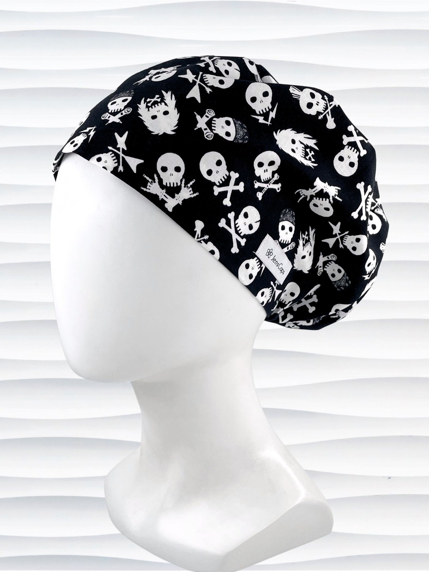 Euro Pixie style surgical scrub cap with white skulls, crossbones, and heavy metal hair all over this black cotton fabric.
