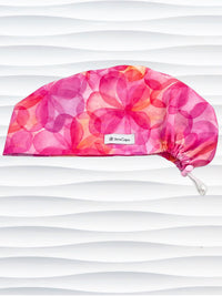 Euro Pixie style surgical scrub cap hat with large flowers in light and dark pinks, purple, and peach sorbet on cotton fabric.
