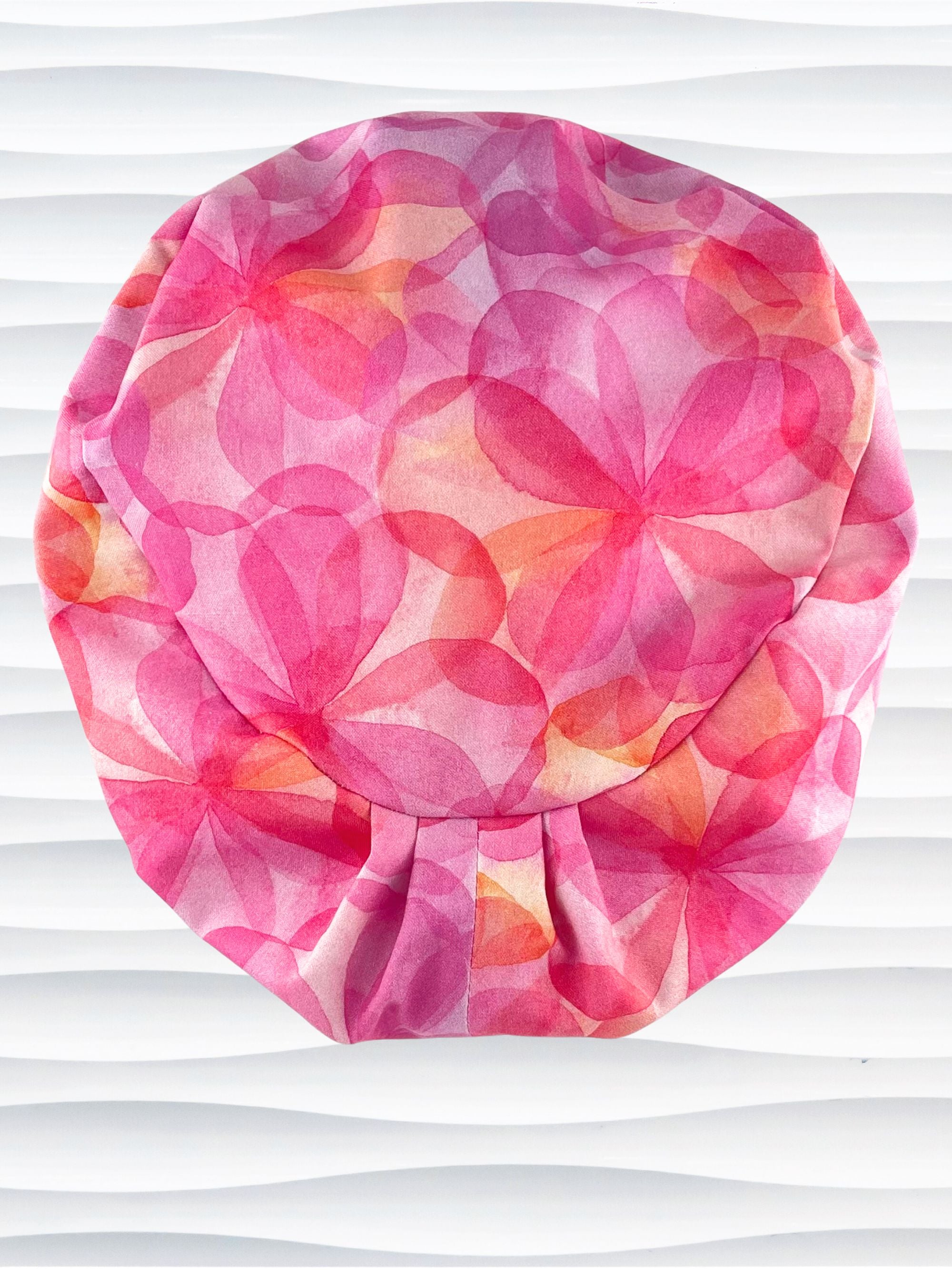 Euro Pixie style surgical scrub cap hat with large flowers in light and dark pinks, purple, and peach sorbet on cotton fabric.