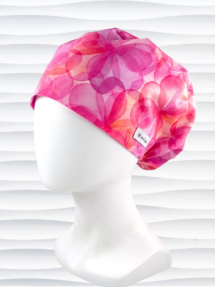 Euro Pixie style surgical scrub cap hat with large flowers in light and dark pinks, purple, and peach sorbet on cotton fabric.