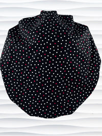 Bouffant style surgical scrub cap by JensCaps with small red hearts and white dots all over this black cotton fabric and displayed on a white mannequin head.