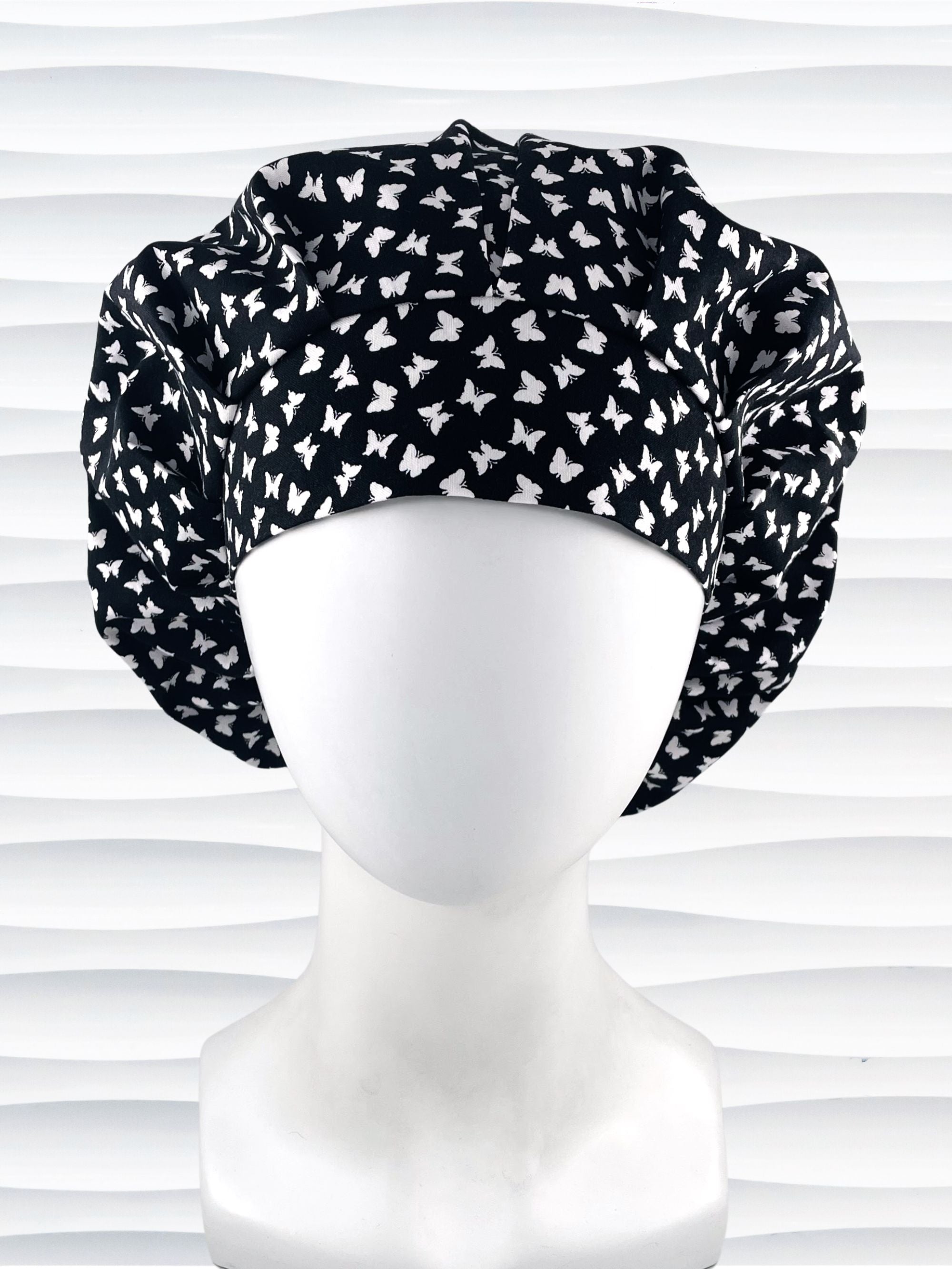 Bouffant surgical scrub cap by JensCaps with white butterflies all over black cotton fabric 