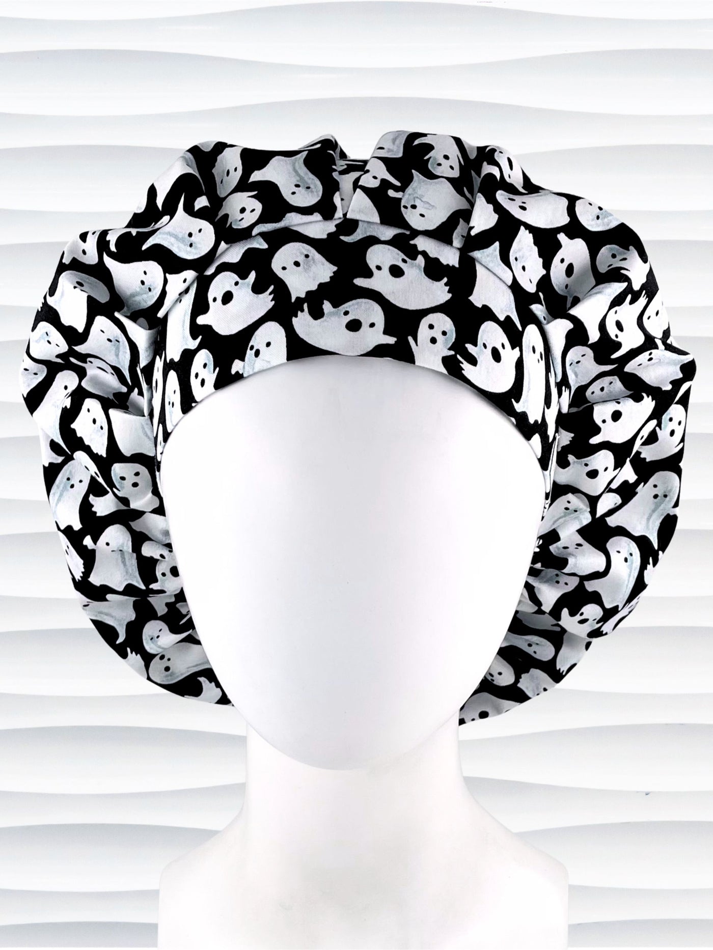 Bouffant style surgical scrub cap with white animated ghosts all over this black cotton fabric.