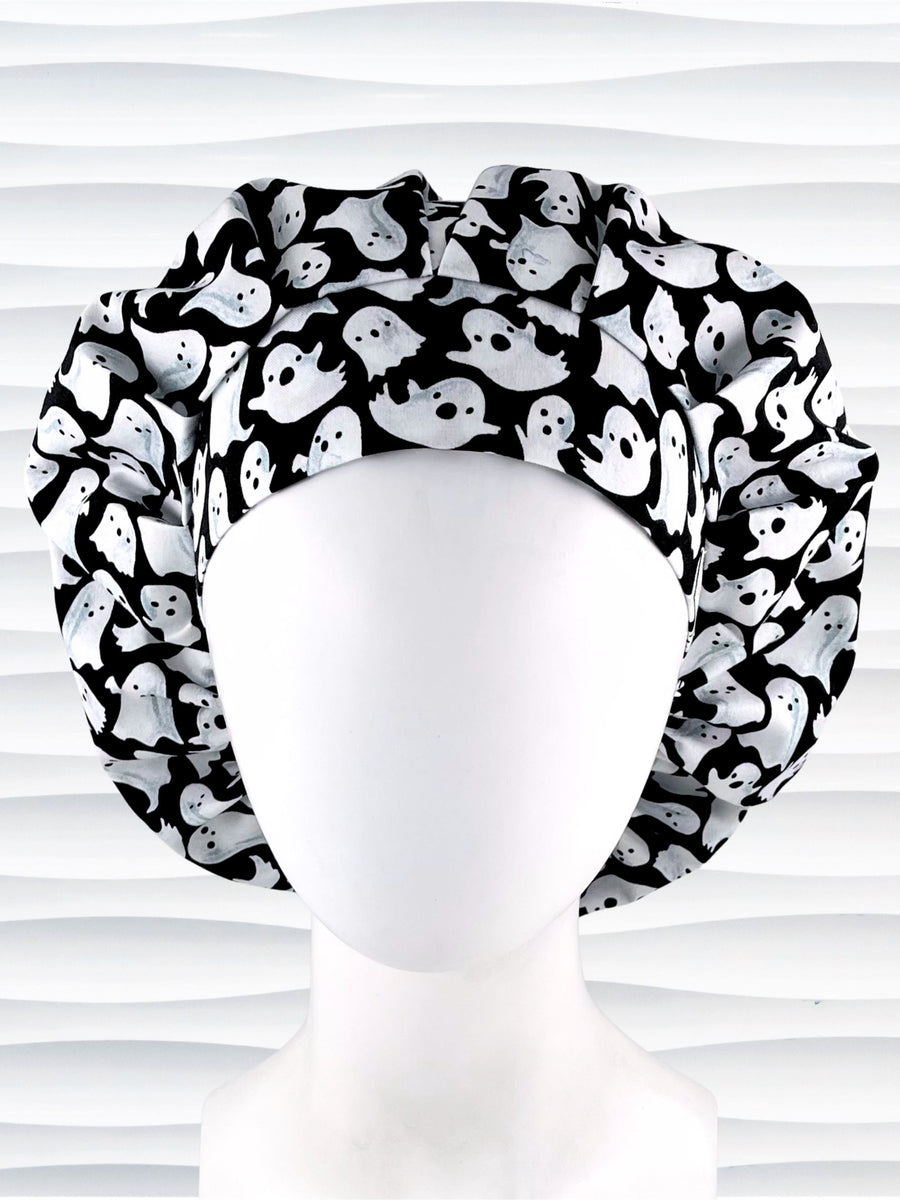 Bouffant style surgical scrub cap with white animated ghosts all over this black cotton fabric.