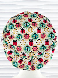 Euro Pixie style surgical scrub cap by JenCaps has ladybugs and flowers in a retro theme on cotton fabric and finished with a grosgrain ribbon.