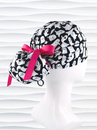 Euro Pony style surgical ponytail scrub cap with friendly white ghosts tossed all over black cotton fabric and finished with grosgrain ribbon ties.