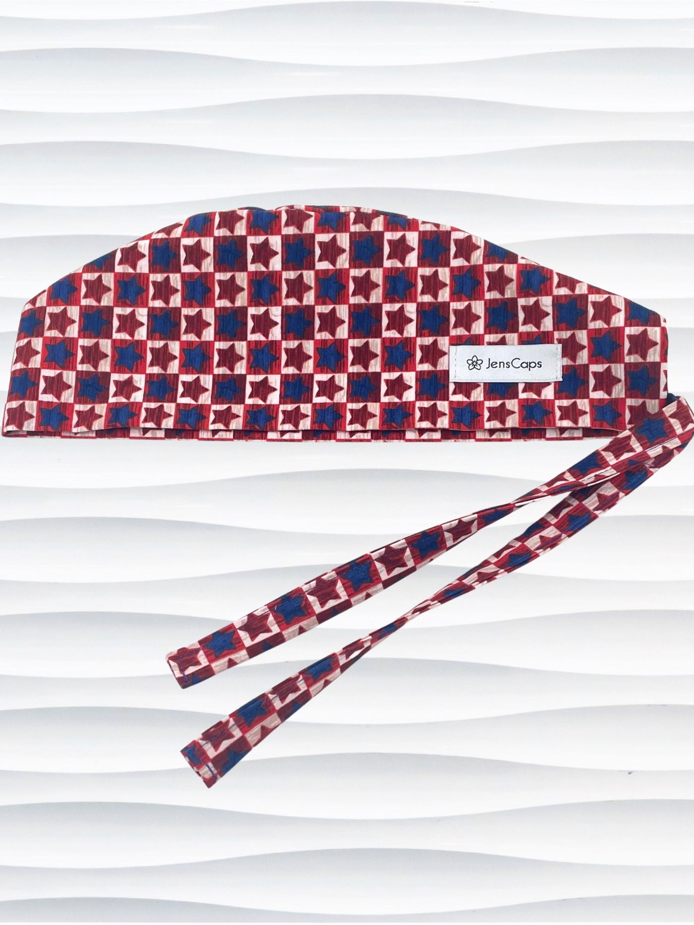 Sugeon style surgical scrub cap with red and blue stars with beige background in plaid style on cotton fabric.