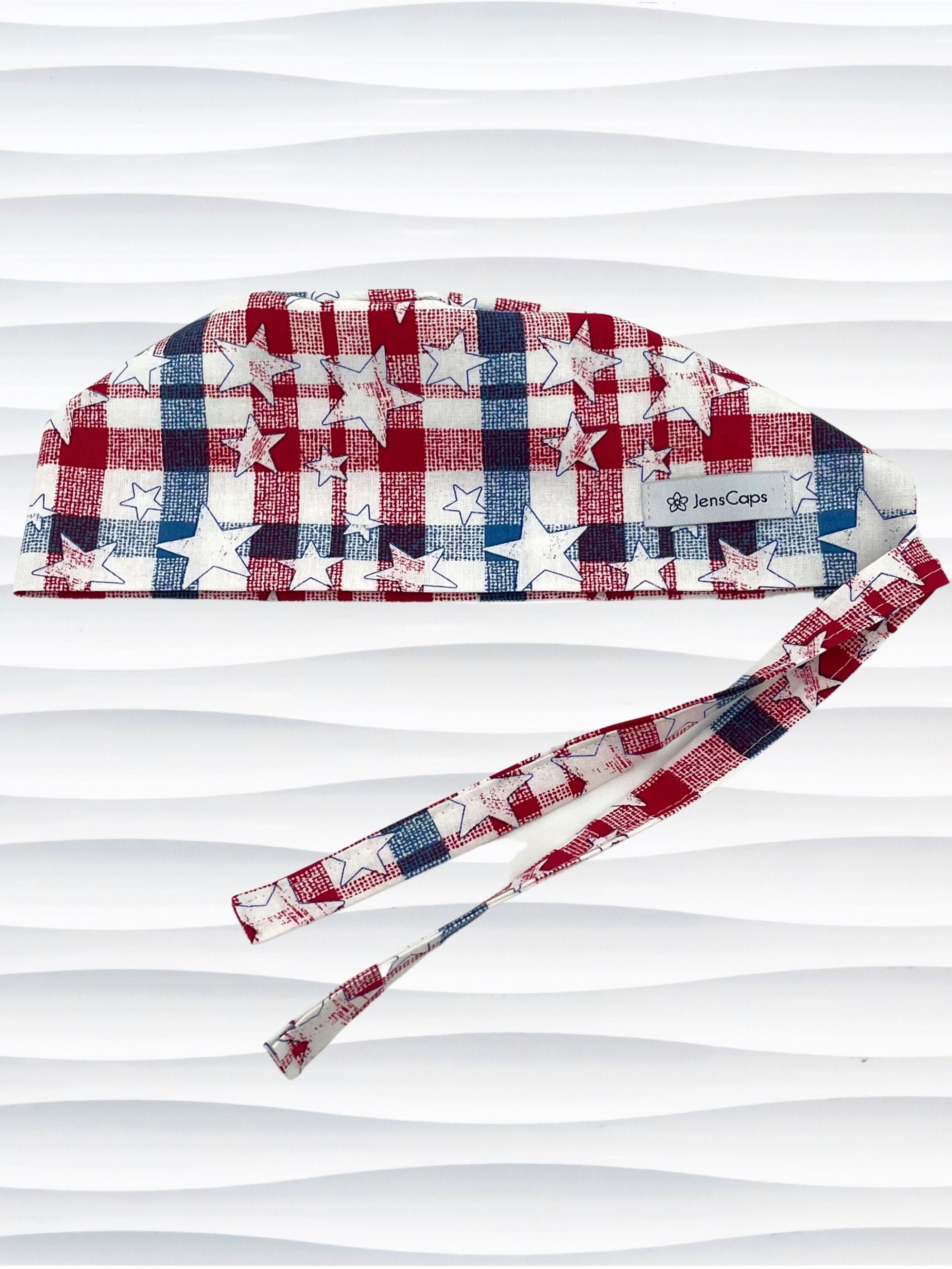 Surgeon style surgical scrub cap with a red and blue plaid print with white stars on cotton fabric.