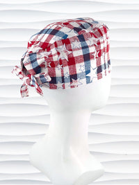 Surgeon style surgical scrub cap with a red and blue plaid print with white stars on cotton fabric.
