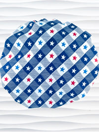 Bouffant style surgical scrub cap with patriotic stars in red white and blue in a modern blue and white buffalo plaid pattern on cotton fabric.