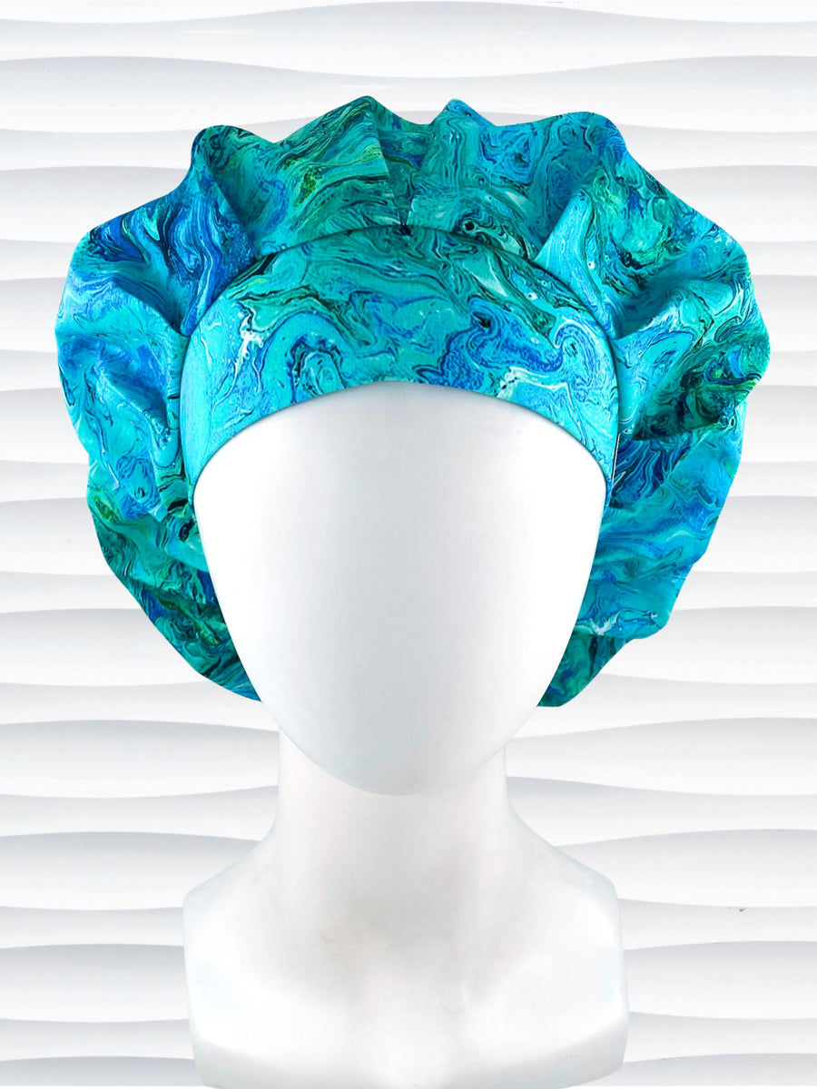Bouffant style surgical scrub cap with a marbled pattern of blues and green that look like ocean tide pools or marbled turquoise on cotton fabric.