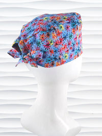 Surgeon style surgical scrub cap by JensCaps with red, blue, yellow, and green fireworks that look like flowers all over a medium blue background on cotton fabric.