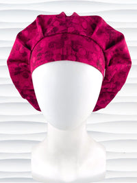 Bouffant style surgical scrub cap with a muted pattern of black circles and lines on deep red or magenta cotton fabric.